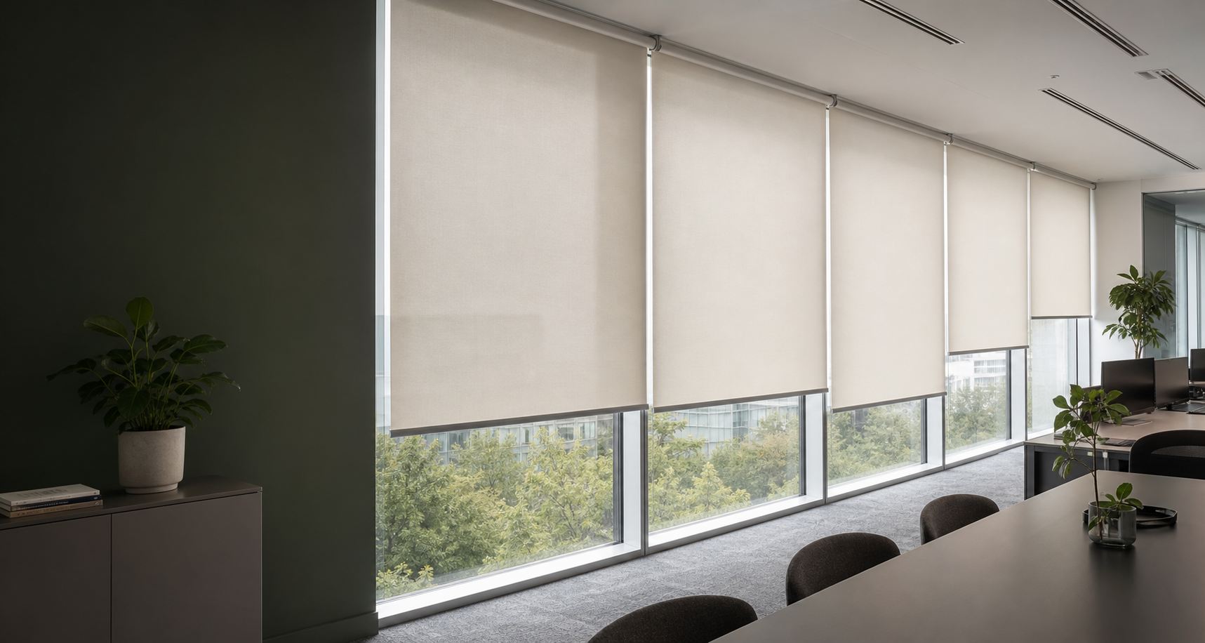 Commercial roller blinds installed across floor-to-ceiling office windows